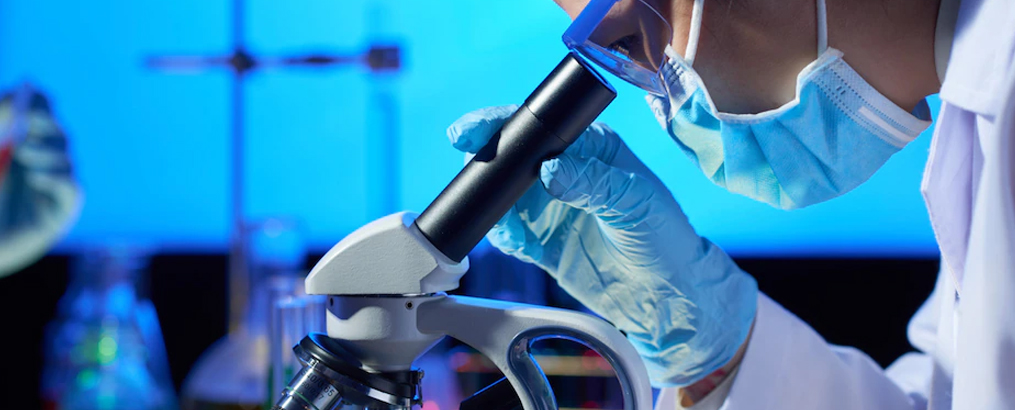 YCLIN laboratory scientist at a microscope